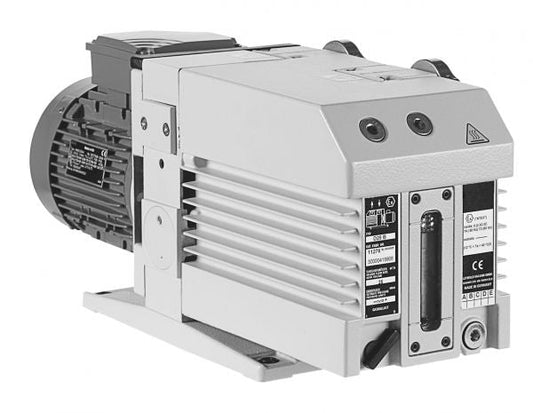 A close-up of the Leybold North America TRIVAC D 25 B industrial vacuum pump highlights its rectangular metal body with cooling fins, a control panel, and a motor. The front side displays labels and warning symbols, emphasizing this sturdy vacuum solution designed for mechanical applications with strong suction capabilities.
